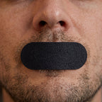 Black bandage on a man's nose